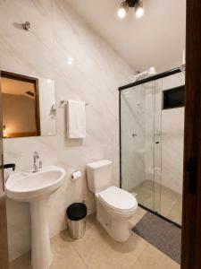a bathroom with a toilet and a sink and a shower at Pousada Estação Rio Branco in Votuverava +20 photos