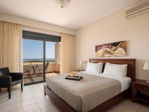 a hotel room with a bed and a view of the ocean at Corali Villas - Seaview, Private Pools, 450 to Beach in Kolymvari