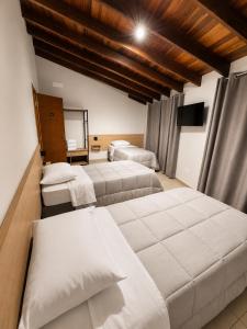 a bedroom with two beds and a mirror at Pousada Estação Rio Branco in Votuverava