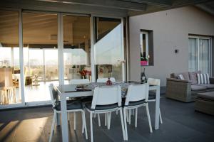 a dining room with a table and white chairs at Villa Mida in Calatabiano