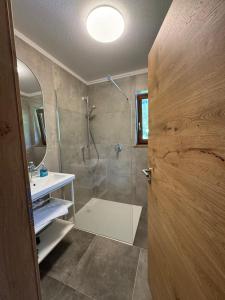 a bathroom with a shower and a sink and a door at Sonnenburg Hotel in Ehrwald +78 photos