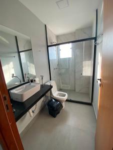 a bathroom with a sink and a toilet and a shower at Piúma Palace Hotel in Piúma