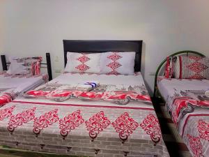 a bed with a red and white bedspread with a car on it at Hotel Bachue Ibagué in Ibagué