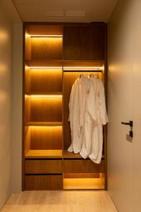 a closet with a white shirt hanging in it at Hotel Berfin in Vlorë