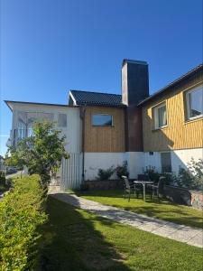 a house with a table and chairs in the yard at Tallgatan Garden in Fjällbacka