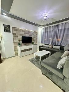 a living room with a couch and a tv at JULYA appartement centre in Tangier
