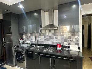 a kitchen with a sink and a washing machine at JULYA appartement centre in Tangier +6 photos