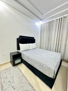 a bedroom with a bed and a window and a rug at JULYA appartement centre in Tangier