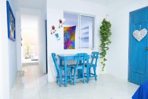 a dining room with blue chairs and a table at Sunset View, Taganga in Taganga
