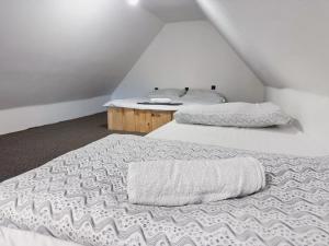 two twin beds in a attic room with a table at Drevenica M&P 2 in Bešeňová