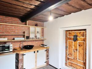 a kitchen with a counter and a brick wall at Drevenica M&P 2 in Bešeňová
