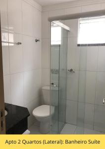 a bathroom with a toilet and a glass shower at Residencial Dona Naime in Bombinhas +28 photos