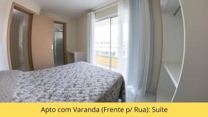 a bedroom with a bed and a large window at Residencial Dona Naime in Bombinhas
