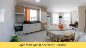 a kitchen and dining room with a table and chairs at Residencial Dona Naime in Bombinhas
