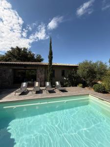 a swimming pool with chairs and a house at Villa Sébastien by Intendance Excellency in Zonza
