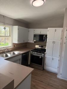 a kitchen with white cabinets and a black stove top oven at Cedarwood Chateau in Cambridge