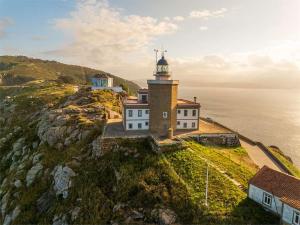 a lighthouse on a cliff next to the ocean at La Casa de la Plaza in Cee