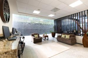 an office with a desk and chairs and a large window at Hotel EJM PREMIUM in Irapuato