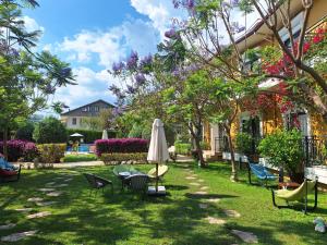 a yard with chairs and an umbrella and chairs at Michelangelo Boutique Hotel Dalyan in Dalyan