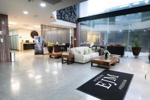 a lobby with couches and tables in a building at Hotel EJM PREMIUM in Irapuato