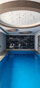 a swimming pool with a ceiling with blue water at Villa Prestiž in Sokolac +46 photos