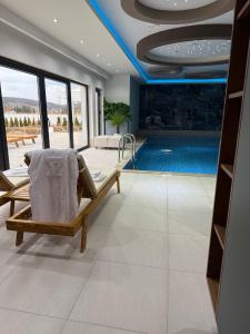 a living room with a swimming pool and a couch at Villa Prestiž in Sokolac