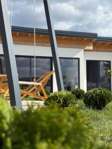 a swinging chair on the porch of a house at Villa Prestiž in Sokolac
