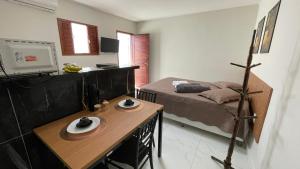 a room with a bed and a table with plates on it at Flat em NATAL- RN in Natal