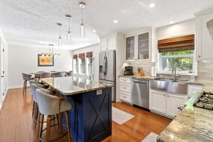 a kitchen with white cabinets and a large island with bar stools at Calm Water Cove in Nebo