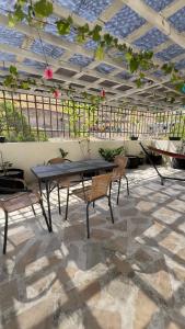 a patio with a table and chairs under a roof at Rodadero Oasis in Santa Marta