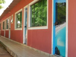 a colorful building with a beach in the background at Sitio Bom Retiro in São Pedro da Aldeia