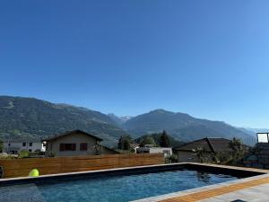 a swimming pool with mountains in the background at Studio Redin in Savièse