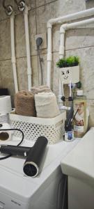 a bathroom counter with a sink with a hair dryer at Stan na dan Harmonija in Nevesinje +7 photos