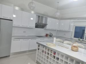 a white kitchen with white cabinets and a counter top at Kalanar villa in Elbasan