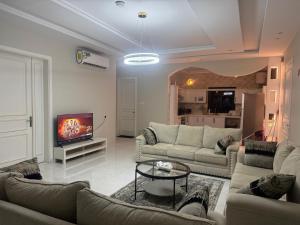 a living room with two couches and a tv at دور فخم كامل 6 غرف بحوش خاص ومدخل سيارة in Taif