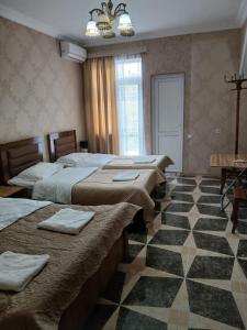 a room with four beds and a checkered floor at Light House in Kutaisi