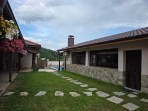 a backyard of a house with a green lawn at Алтъна Калофер in Kalofer