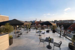 a patio with tables and chairs and umbrellas at StadtBlick Hotel in Bad Salzuflen