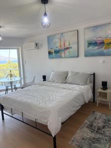 a bedroom with a bed and a table and a window at Yialos Kalamos in Kalamos