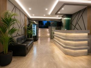 a lobby with a leather couch and a bar at Perla Halkidiki in Kallithea Halkidikis