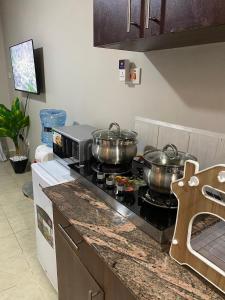 two pots on top of a stove in a kitchen at The Cozy Corner Studio in Ruaka