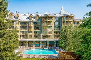 a large apartment building with a swimming pool and trees at Cascade Lodge in Whistler