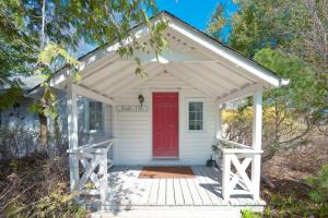 a small white house with a red door at Lakefront Cottage Private Beach & & Kayaks in Georgina