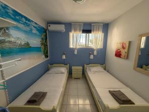 two beds in a room with a painting on the wall at Casa Helios Fourka Beach Retreat in Skala Fourkas