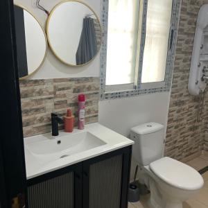 a bathroom with a white sink and two mirrors at La Villa Fleur d'Edene in Abidjan +2 photos