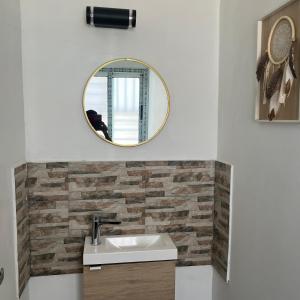 a bathroom with a sink and a mirror at La Villa Fleur d'Edene in Abidjan