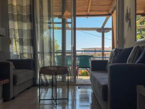 a living room with a couch and a table at Casa Helios Fourka Beach Retreat in Skala Fourkas