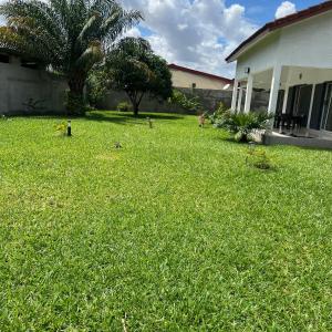 a yard of a house with a green lawn at La Villa Fleur d'Edene in Abidjan