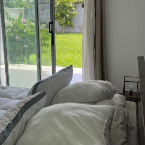 a bedroom with two beds with pillows and a window at La Villa Fleur d'Edene in Abidjan