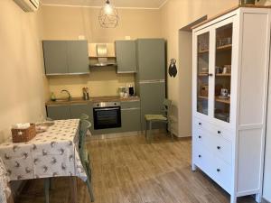 a small kitchen with a table and a white cabinet at Domu de Ziu Peppino in Sìnnai +11 photos